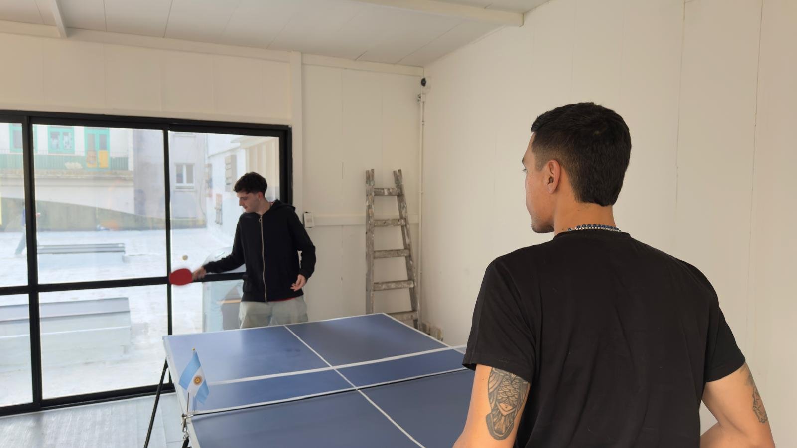 Compañeros jugando al ping pong en la oficina